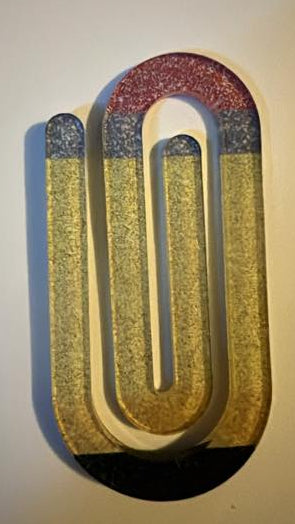 Decorative wall art with a U-shaped design in red, gold, and blue on a plain background