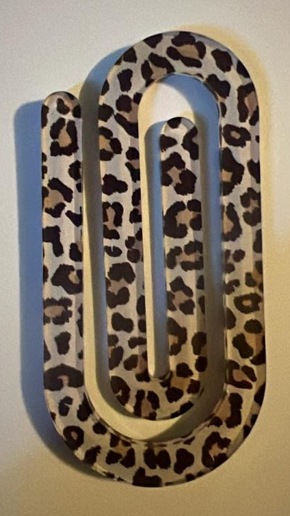 Leopard print paperclip on a plain background