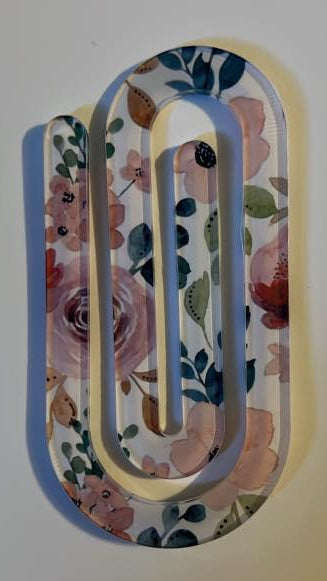 Decorative paper clip with floral pattern on a white background