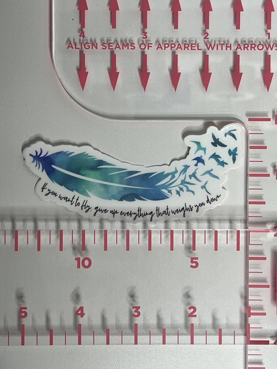 Feather-shaped cutout with text on a ruler for measurement