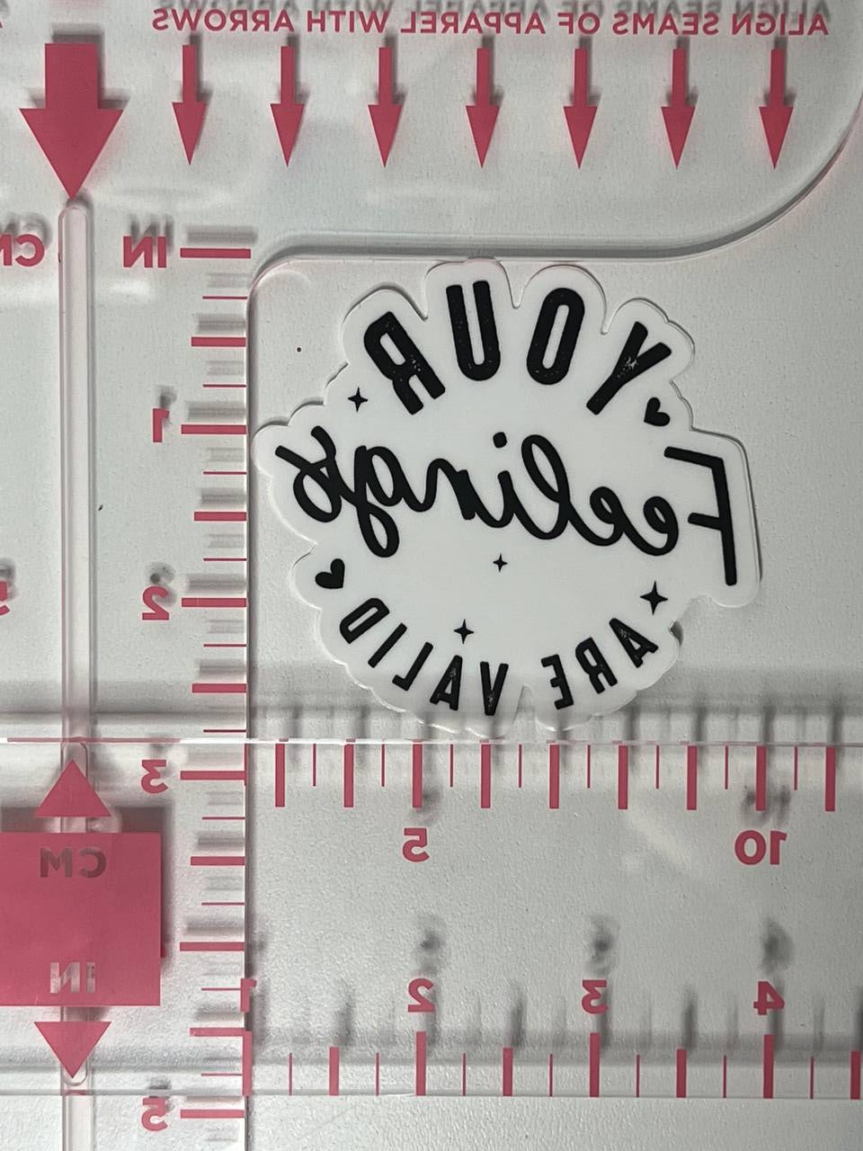 Sticker with 'Your Feelings Are Valid' text on a ruler