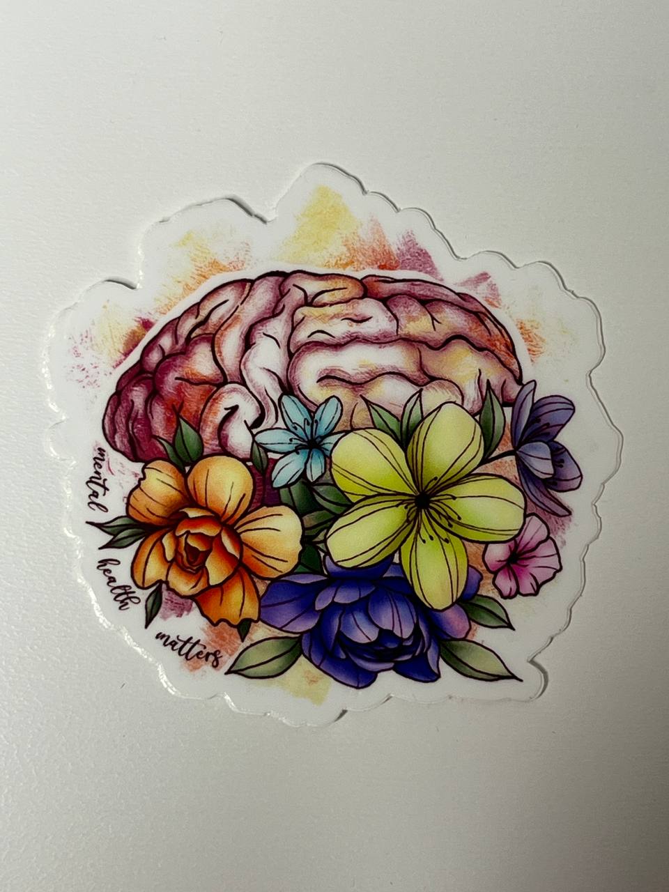 Sticker with a brain surrounded by colorful flowers on a white background