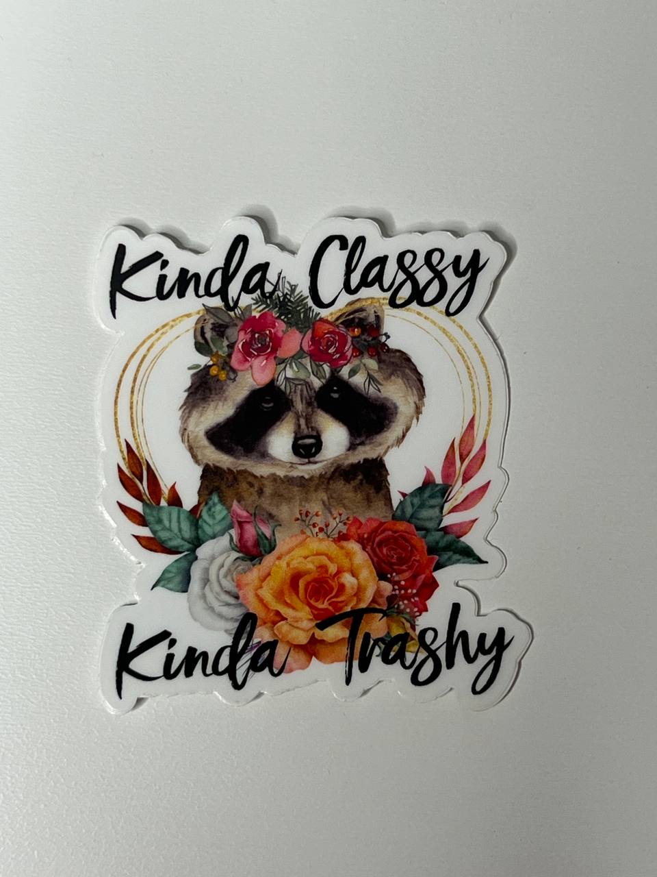 Sticker with a raccoon illustration and floral elements on a white background