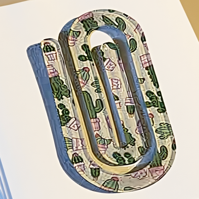 Decorative paper clip with cactus pattern on a notebook